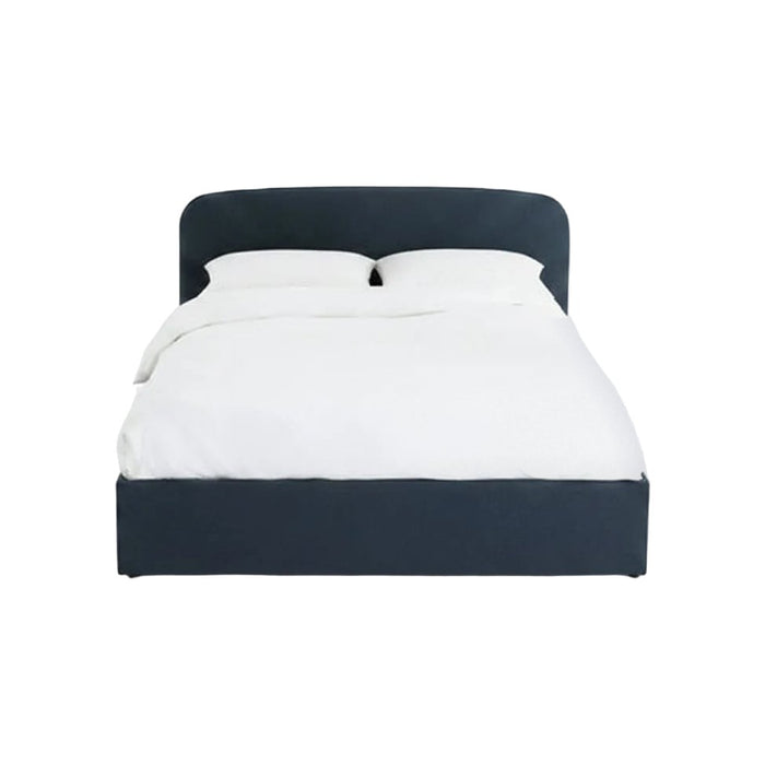 Lit coffre Baumain en tissu bleu marine avec tête de lit arrondie et linge de lit blanc, vu de face