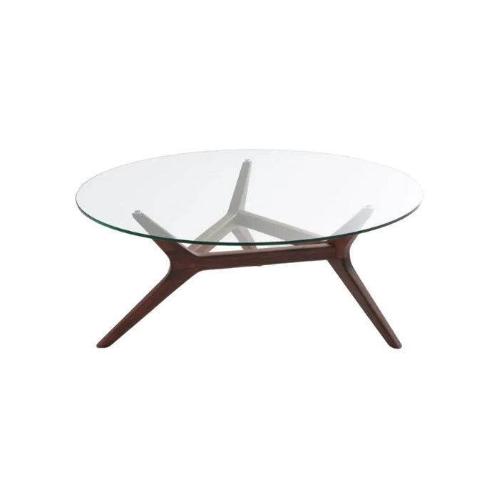 Table basse Maricielo à plateau rond en verre et piètement en noyer massif, sur fond blanc